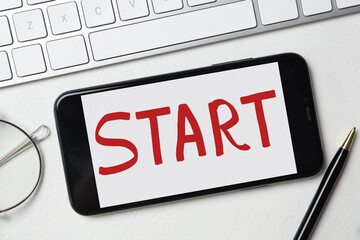 Poster - Smartphone with word Start and keyboard on white table, flat lay