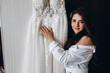 © dimadasha - Morning of the bride. Preparing the bride for the upcoming wedding. The bride shows off her white wedding dress.