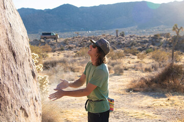 Young Male Adult Climbing Guide dusting his hands with climber's chalk before a demo. 