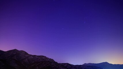 Wall Mural - Night starry sky, silhouette of mountain and purple-blue night sky, time-lapse