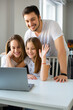 © Stavros - Vertical photo of a happy family during online video call. Communication with relatives via the Internet.