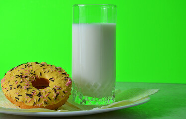 Yellow donut and milk on a green background.