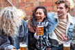 © william87 - People enjoying a beer together at pub brewery - Happy laughing man and women talking and raising pint glass - Lifestyle and drink concepts in London