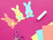 Easter bunny decoration. Paper cut DIY holiday colorful rabbits.Top view,  copy space on pink  background.