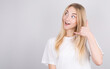 © Studio Nova - A young girl makes a surprised face, looks up, making a telephone gesture with her hand and fingers, as she talks on the phone. with copyspace