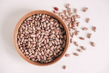 Raw Dry Beans In A Wooden Bowl On A White Background. Top View. Copy, Empty Space For Text