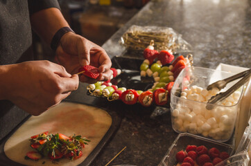 Chef in kitchen assembling fruit, strawberry, grape and bonbon banners 2