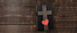 Bible book on a wooden table. Wooden cross of Jesus. Red heart. The concept of love for God's Word.