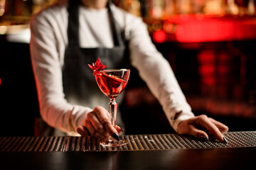 glass with splashing red drink decorated with flower on bar counter