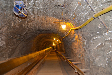 Stairs inside tunnel in a salt mine with lantern and ventilation