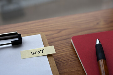 Poster - There is a notebook, a pen, and a clipboard with a sticky note stuck to it that says WoT written on it. It was an abbreviation for Web of Things.
