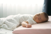 Asian Little Boy Lying Down On A Bed. A Cute Infant Sleepy On A Pink Pillow, White Blanket In Afternoon Bedtime With Sweet Dream, Relax And Happiness.