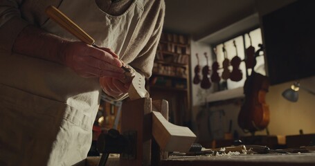 Sticker - Cinematic shot of experienced master artisan luthier painstaking detail work on fine quality wood violin in creative workshop.Concept of spiritual instrument,handmade, art, orchestra, artisan,passion