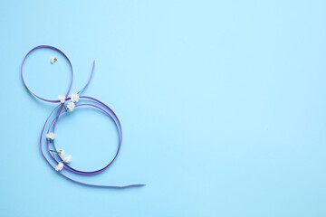 Figure 8 made of violet ribbon on color background. International Women's Day celebration