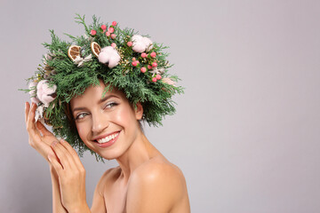 Wall Mural - Happy young woman wearing wreath on grey background. Space for text