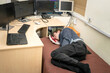 © Климов Максим - Tired guy sleeps in front of monitors in the office. The monitoring operator is lying on the bed. A man from the technical department sleeps on a bed at his workplace.