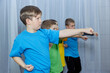 © andreyfire - Boys athletes in multi-colored T-shirts perform a hand punch on a light background