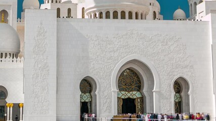 Wall Mural - Entrance to Sheikh Zayed Grand Mosque timelapse located in Abu Dhabi - capital city of United Arab Emirates. It is largest mosque in UAE. Blue cloudy sky