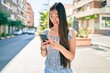 © Krakenimages.com - Young chinese woman smiling happy using smartphone at street of city.