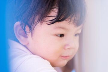 Close up of boy's face is sweet smile. Blur some objects in front of view, secretly taking pictures of children playing. Baby was sweating. Child 1-2 years old.