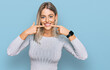 © Krakenimages.com - Beautiful blonde woman wearing casual clothes smiling cheerful showing and pointing with fingers teeth and mouth. dental health concept.