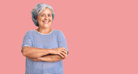 Senior woman with gray hair wearing casual striped clothes happy face smiling with crossed arms looking at the camera. positive person.