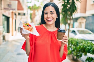 Wall Mural - Young latin girl smiling happy having breakfast at the city.