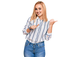 Beautiful caucasian woman wearing casual clothes pointing to the back behind with hand and thumbs up, smiling confident