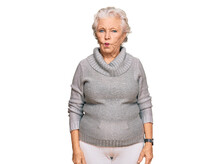 Senior Grey-haired Woman Wearing Casual Winter Sweater Making Fish Face With Lips, Crazy And Comical Gesture. Funny Expression.