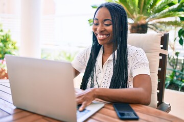 Young african american woman smiling happy working using laptop at terrace