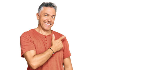 Wall Mural - Handsome middle age man wearing casual clothes cheerful with a smile of face pointing with hand and finger up to the side with happy and natural expression on face