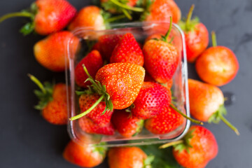 Wall Mural - Red fresh strawberry on black plate