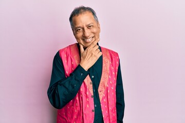 Poster - Middle age indian man wearing traditional indian clothes looking confident at the camera smiling with crossed arms and hand raised on chin. thinking positive.