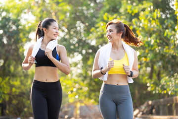 Wall Mural - asian athletics couple woman jogging and exercising together in public park in the evening