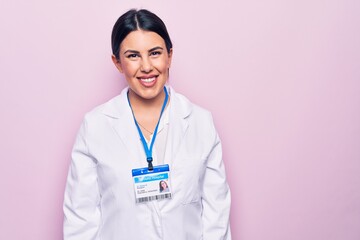 Sticker - Young beautiful doctor woman wearing stethoscope and id card over isolated pink background with a happy and cool smile on face. Lucky person.