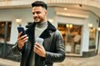 © Krakenimages.com - Young arab man using smartphone and drinking coffee at the city.