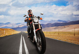 Fototapeta  - a biker on a motorcycle rides on an asphalt road in the mountains