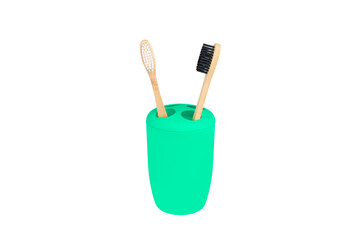 Family set of two bamboo toothbrushes in green glass on white isolated background. Concept for a natural organic oral care product. Zero waste concept without harm to nature. copy space. top view