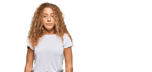 beautiful caucasian teenager girl wearing casual white tshirt relaxed with serious expression on fac