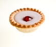 A sweet and tasty individual cherry Bakewell tart isolated on a white background