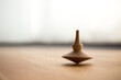 wooden Spinning top in action on wooden flor, rotating totem in motion