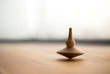 Wooden Spinning Top In Action On Wooden Flor, Rotating Totem In Motion