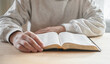 © Maria - senior man praying, reading  an old Bible in his hands.