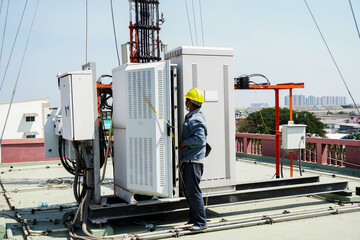 Electrical control cabinet, Engineer standing in front of the control cabinet on the rooftop. technician worker repair telecommunication.