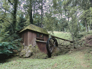 Wasserrad mit kleinem beleuchtetem Schwarzwaldhäuschen im Kurpark von Bad Wildbad - Water wheel with a small illuminated black forest wooden hut in the spa gardens of Bad Wildbad Germany