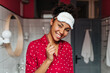 © Look! - Dark-skinned woman in white sleeping mask is smiling and posing cute in bath with toothbrush