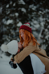 Sticker - Beautiful view of the boy lifting and hugging his girlfriend at the snow park