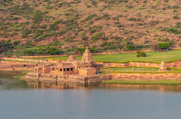 Wall Mural - Badami, Karnataka, India - November 7, 2013: Closeup of Bhootnath Temple and its green lawns on east shore of Agasthya Lake. Reddish rock hills in back under sunset twilight. 