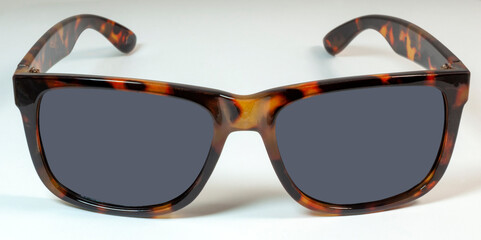 Tortoise shell sunglasses on white background.