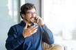 © Joao - Casual businessman wearing glasses talking on the phone. Successful male portrait sitting on a shair at the office by the window